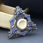 Spinner scientifico decorativo in metallo con dettagli blu e design elaborato, perfetto come oggetto di decorazione o collezione scientifica.