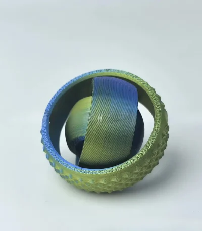 Pallina decorativa con superficie metallizzata e texture 3D, ideale come oggetto di decorazione scientifica o da collezione. Perfetta per appassionati di scienza e design innovativo.
