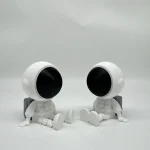 Due figure di astronauti in miniatura con teste nere e corpi bianchi, ideali come decorazioni scientifiche o oggetti da collezione.
