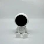 Piccolo robot astronautico bianco con visore nero, simbolo di tecnologia e innovazione scientifica, ideale come decorazione o oggetto da collezione.
