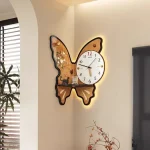 Orologio a forma di farfalla con dettagli scientifici e decorativi, illuminato da luci a LED, appeso su una parete bianca in un ambiente moderno.