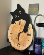 Orologio da parete con design di gatto nero e tronco di legno naturale, perfetto come decorazione originale e simpatica per la casa o l'ufficio.