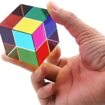 Cubo di Rubik colorato tenuto tra le dita di una mano, simbolo di logica e problem solving, perfetto come decorazione scientifica o oggetto da collezione.