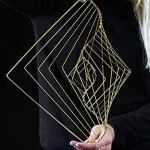 Decorazione in filo di metallo dorato con forme geometriche sovrapposte, ideale come oggetto decorativo scientifico e artistico.