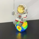 Modello LEGO di un astronauta in tuta spaziale su un pianeta colorato, decorazione scientifica originale e creativa.
