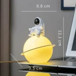 Decorazione luminosa a forma di pianeta con astronauta, perfetta come oggetto scientifico e decorativo, con dimensioni di circa 12 cm di altezza e 9,8 cm di larghezza.