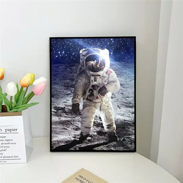Immagine di un astronauta sulla superficie lunare con un cielo stellato sullo sfondo, in una cornice nera, ideale per decorazioni scientifiche e ambienti educativi.