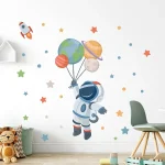 Astronauta che tiene palloni a forma di pianeti e Terra, decorazione spaziale per ambienti bambini, tema universo e esplorazione spaziale.