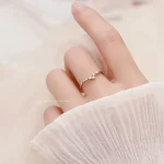 Anello della Costituzione indossato su una mano femminile, con sfondo neutro e abbigliamento chiaro, simbolo di legalità e diritto.
