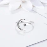Anello in argento con design luna e stella decorata con zirconi, perfetto come gioiello decorativo o simbolico.