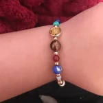 Bracciale di moda con perline multicolore e dettagli metallici, ideale come accessorio decorativo e scientifico.