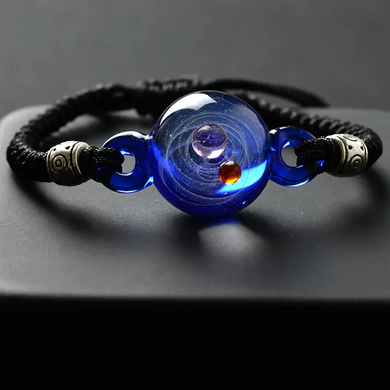 Bracciale con sfera di vetro blu e dettagli metallici, perfetto come decorazione scientifica o accessorio di stile. Design elegante e affascinante, ideale per appassionati di scienza e moda.