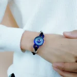 Pendente in vetro di Murano blu con dettagli artistici, indossato come bracciale decorativo.