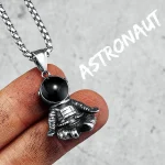 Collana con ciondolo astronauta in metallo e sfera nera, ispirato allo spazio.