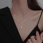 Collana elegante con pendente a forma di stella e pianeta, perfetta come accessorio decorativo e scientifico. Realizzata in metallo lucido, ideale per appassionati di astronomia e design raffinato.