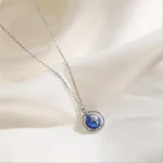 Collana con pendente a forma di pianeta Terra in vetro blu e argento.