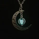 Collana con pendente a forma di luna decorata con dettagli intricati e un cristallo blu incastonato, perfetta come accessorio decorativo e simbolico.