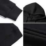 Dettagli di una maglietta nera con polsini elasticizzati e tessuto morbido, ideale per abbigliamento casual e sportivo.