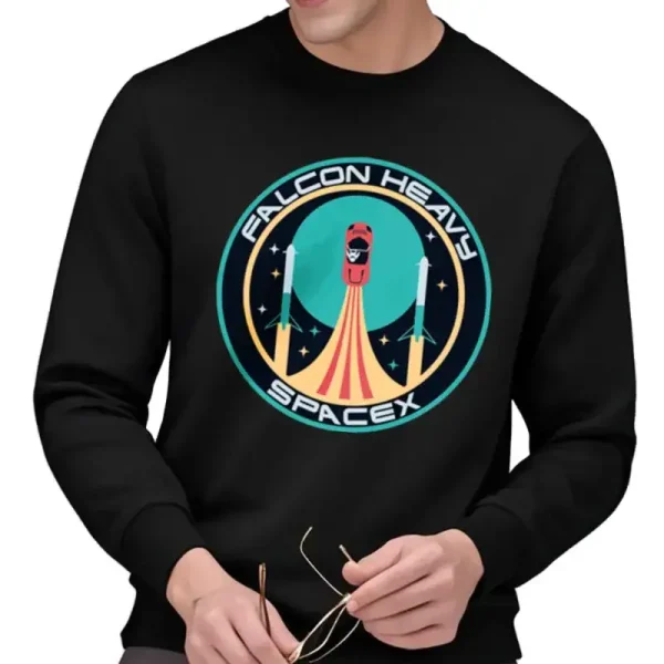 T-shirt nera con logo Falcon Heavy SpaceX, che rappresenta un razzo in lancio con uno sfondo stellato, ideale per gli appassionati di aerospaziale e tecnologia spaziale.