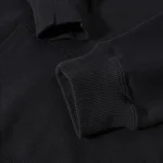 Maglietta nera con polsini a coste, dettaglio di un capo di abbigliamento casual e versatile, ideale per look informali e comfort quotidiano.