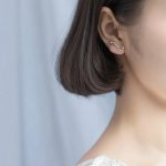 Orecchino a forma di costellazione zodiacale in argento, indossato da una donna con capelli corti, elegante e moderno, perfetto come decorazione scientifica o accessorio di moda.