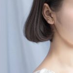 Orecchino a forma di costellazione zodiacale indossato sull'orecchio di una donna, accessorio decorativo scientifico elegante e originale.