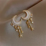 Orecchini pendenti a forma di luna e stelle in oro con zirconi, ideali come accessori eleganti e originali. Perfetti per aggiungere un tocco di magia e raffinatezza al tuo look.
