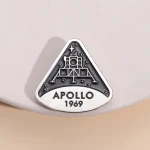 Piastra commemorativa Apollo 11 con logo della missione spaziale Apollo 1969, simbolo storico dell'esplorazione lunare.