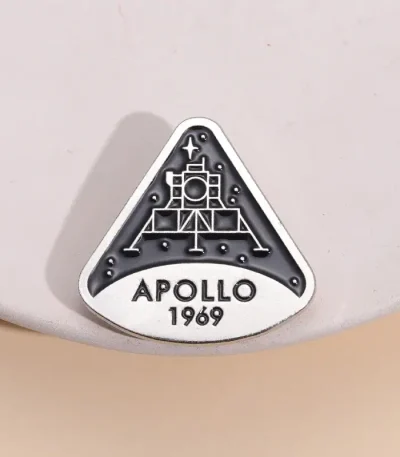 Piastra commemorativa Apollo 11 con logo della missione spaziale Apollo 1969, simbolo storico dell'esplorazione lunare.