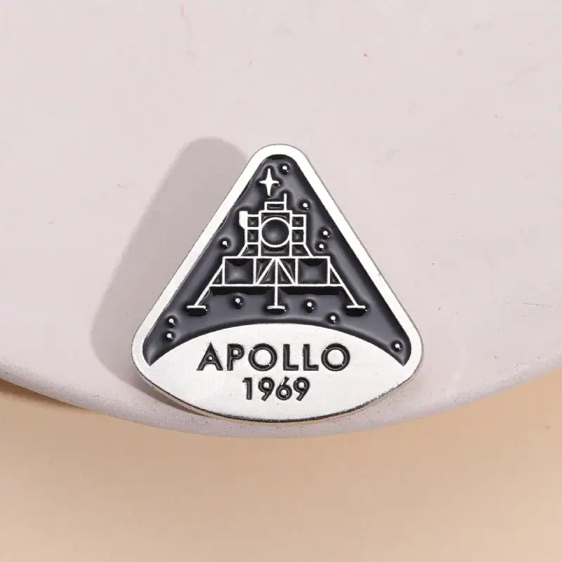 Piastra commemorativa Apollo 11 con logo della missione spaziale Apollo 1969, simbolo storico dell'esplorazione lunare.