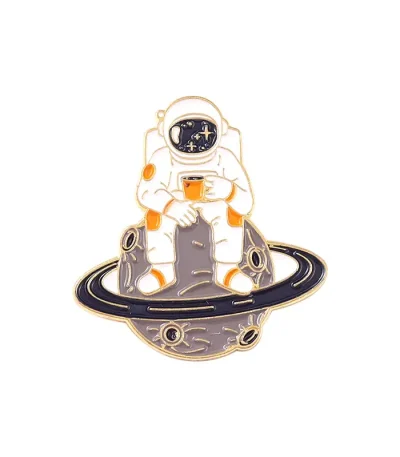 Astronauta in tuta spaziale seduto su un pianeta con anelli, che tiene una tazza di caffè, simbolo di esplorazione e relax nello spazio.