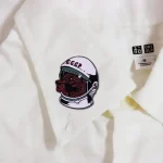 Pezzo decorativo con patch di un astronauta con casco e volto di un leader sovietico, simbolo di esplorazione spaziale e storia sovietica, ideale per appassionati di scienza e cultura pop.
