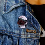 Pendente decorativo con cane e simbolo CCCP, indossato su una giacca di jeans, perfetto come accessorio alternativo e originale.