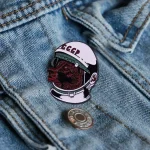 Spilla con stemma sovietico e testa di orso in casco spaziale, applicata su tessuto jeans. Perfetta come decorazione scientifica o oggetto da collezione.