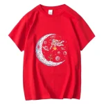 Maglietta rossa con stampa di un astronauta che fluttua vicino a una luna, decorata con pianeti e stelle, perfetta per gli appassionati di spazio e scienza.