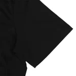 Dettaglio di una camicia nera con maniche corte, tessuto morbido e taglio classico, ideale per un look elegante e casual.