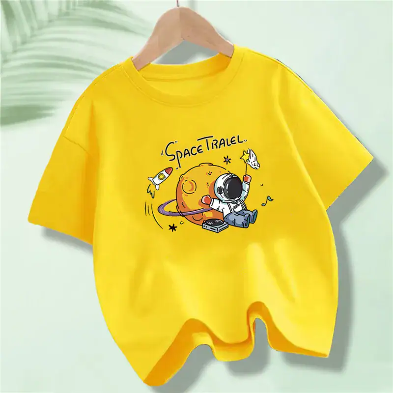 T-shirt gialla con stampa di un pianeta astronauta e razzi, perfetta come decorazione scientifica o regalo per appassionati di spazio.