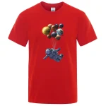 T-shirt rossa con stampa di un astronauta che vola tra pianeti e corpi celesti, ideale per appassionati di spazio e scienza.