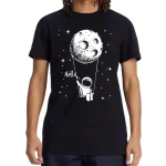 T-shirt nera con stampa di un astronauta che tiene una corda collegata a una luna, con la scritta "Hello" e stelle sullo sfondo, perfetta per appassionati di spazio e scienza.