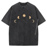 Maglietta oversize nera con stampa di fasi lunari e stelle dorate, perfetta per gli appassionati di astronomia e decorazioni scientifiche.