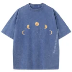 T-shirt blu con stampa delle fasi lunari in tonalità beige, ispirata ai cicli lunari e all'astronomia, perfetta per appassionati di scienza e astronomia.