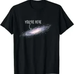 Maglietta nera con stampa di una galassia e testo "You're Here" in bianco, ispirata all'universo e alla scienza.