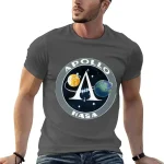 Maglietta grigia con logo Apollo e NASA, raffigurante un'illustrazione spaziale con pianeti e navicella.