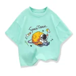 Un maglietta color menta con stampa di un pianeta, astronauta e razzi, perfetta come decorazione scientifica o abbigliamento originale.