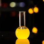 Vaso di laboratorio con liquido giallo brillante, oggetto decorativo scientifico ideale per appassionati di chimica e scienza, perfetto come decorazione originale e educativa.