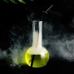 Beuta di vetro con liquido giallo fluorescente e vapori, atmosfera misteriosa e scientifica.
