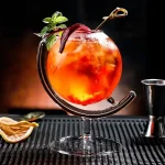 Cocktail colorato in bicchiere di vetro con frutta, menta e cannuccia, perfetto come decorazione scientifica o oggetto da collezione.