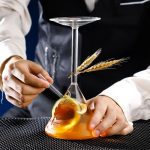 Immagine di un esperimento scientifico con becher, pipetta e decorazioni di grano, simbolo di ricerca e scienza.