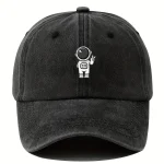 Cappellino nero con ricamo di astronauta stilizzato bianco, perfetto come accessorio decorativo e casual per appassionati di scienza e spazio.