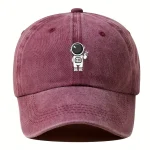 Cappellino con ricamo di astronauta stilizzato, in tessuto morbido e color bordeaux, perfetto per gli appassionati di spazio e scienza.